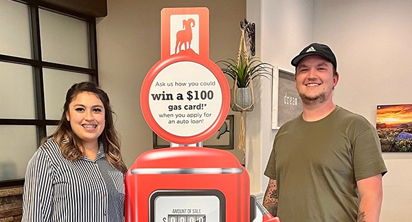 Pareja feliz sonriendo para una foto con el surtidor de gasolina promocional de Great Basin