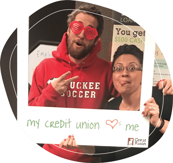 Male and female posing in a makeshift photo frame that says "My Credit Union loves me"