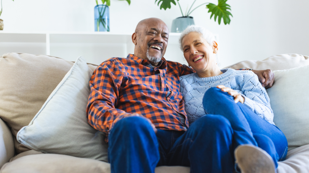 older couple on the couch embracing, laughing