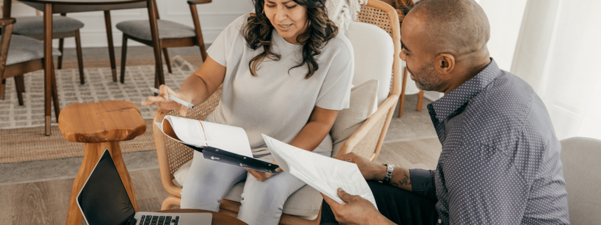 couple in their living room looking over their budget/financials